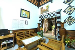 a dining room with a table and wooden chairs at Quang Xuong Homestay in Hoi An