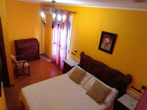 a bedroom with a bed and a yellow wall at Bonito apartamento in Las Negras