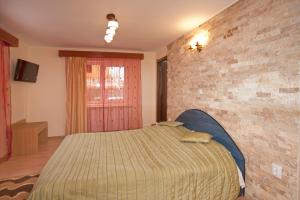 een slaapkamer met een bed en een bakstenen muur bij Casa Tudor in Sinaia