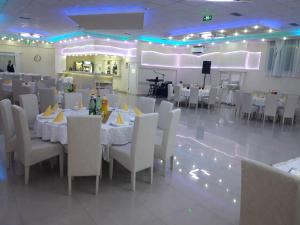 a banquet hall with white tables and white chairs at Olympic Residence Hotel in Prokuplje