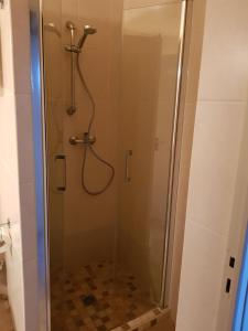 a shower with a glass door with a shower head at Hotel & Restaurant le Saint Jean in Cargèse