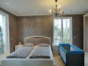een slaapkamer met een bed en een kroonluchter bij SeWeR Apartment in Baden-Baden