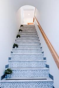 uma escada com escadas azuis e brancas com vasos de plantas em Casas de Mar - Búzio em Olhão