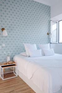 um quarto com 2 camas e uma parede coberta de papel de parede em Casas de Mar - Búzio em Olhão