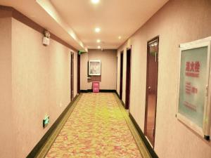 einen langen Flur mit Teppichboden in einem Gebäude in der Unterkunft GreenTree Inn Anhui Hefei Mengcheng Road Beierhuan Express Hotel in Hefei