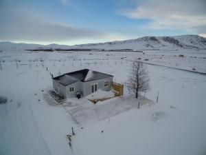 een klein huis midden in een met sneeuw bedekt veld bij Gamla Húsið - The Old House in Selfoss