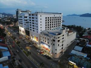 a large white building next to a street with cars at Langkasuka Express in Kuah