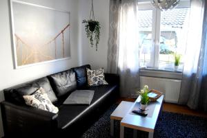 a living room with a black leather couch and a table at Apartment Unna-Massen mit eigener Sauna in Unna