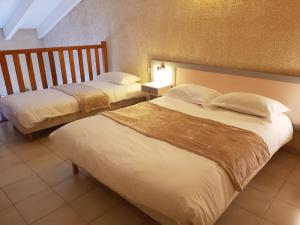 a hotel room with two beds and two lamps at Hotel & Restaurant le Saint Jean in Cargèse