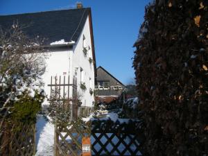 バート・シャンダウにあるFerienwohnung Geißlerの雪の中の柵のある白い家
