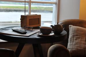 a table with a computer and two cups on it at The Driftwood in Sligo