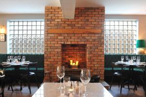a dining room with tables and a brick fireplace at The Driftwood in Sligo