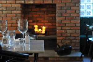 a table with wine glasses and a brick fireplace at The Driftwood in Sligo