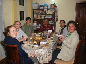 een groep mensen die rond een tafel zitten te eten bij Edificio Danny Javier in Quito