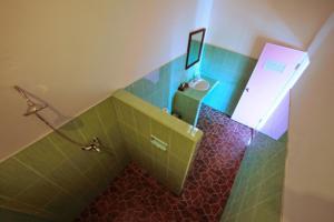 a bathroom with a sink and a toilet with green tiles at Warung Ary & Home Stay in Amed