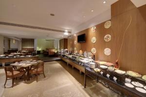 a buffet line in a restaurant with plates on the wall at Pride Hotel Pune in Pune