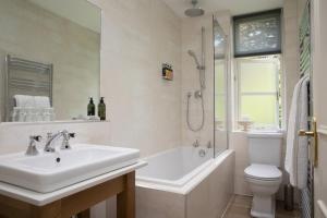 a bathroom with a sink and a toilet and a shower at Hazel Bank Country House Borrowdale Valley in Rosthwaite