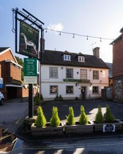 a white building with a sign in front of it at Greyhound Inn Wilton in Salisbury