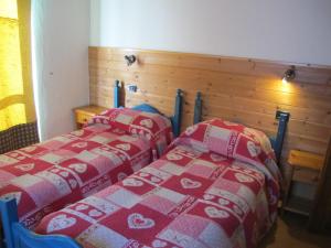 - deux lits assis l'un à côté de l'autre dans une pièce dans l'établissement Villa Zita, à Champoluc