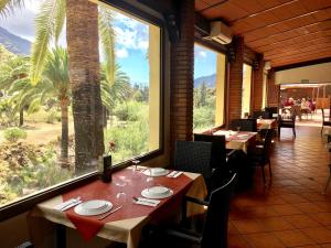 a restaurant with tables and chairs and a large window at La Villa in Mogán