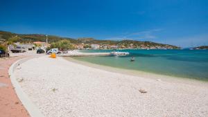 a sandy beach with a boat in the water at Villa Nada in Vinišće