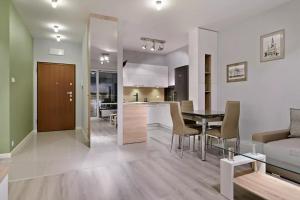 a kitchen and living room with a table and a couch at Strict center Towarowa in Poznań