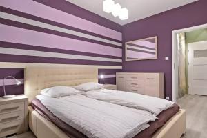 ein Schlafzimmer mit lila Wänden und einem großen Bett in der Unterkunft Strict center Towarowa in Posen