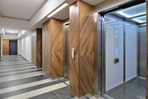 a hallway with wooden doors and a hallway with tile floors at Strict center Towarowa in Poznań