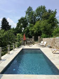- une piscine dans un jardin avec une table et des chaises dans l'établissement Corte Villa Donati, à Cissano