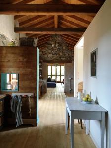 - une cuisine avec une table dans une chambre dotée de plafonds en bois dans l'établissement Corte Villa Donati, à Cissano