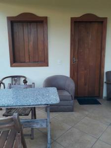 Habitación con mesa, sofá y puerta en Pousada Do Mestre, en Pirenópolis