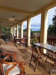 un patio con mesas y sillas en un porche en Pousada Do Mestre, en Pirenópolis