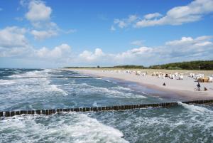 una spiaggia con un gruppo di persone sulla sabbia di Ferienzimmer in Graal-Müritz a Graal-Müritz