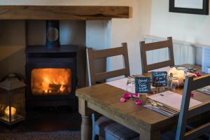 a wooden table with a fire place next to a fireplace at Greyhound Inn Wilton in Salisbury