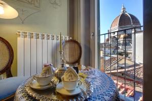 a table with a tea set on it with a view at Romantic apartment in the heart of Florence in Florence