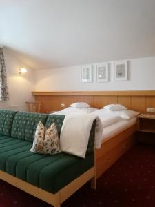 a bedroom with a large bed with a green couch at Appartement Bruckberg in Zell am See