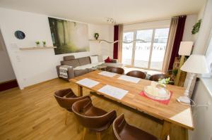 salon z drewnianym stołem i krzesłami w obiekcie Finest Kitzblick Golf Suites by All in One Apartments w mieście Zell am See