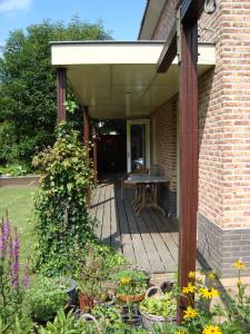 un portico di una casa con tavolo e fiori di Vakantiehuis Petrarca a Putten