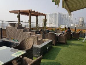 a patio with tables and chairs on a roof at Platinum Palace in Gurgaon