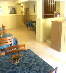 a dining room with tables and chairs with flowers on them at Hotel Ariosto centro storico in Reggio Emilia