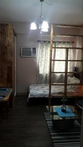 een slaapkamer met een stapelbed en een tafel bij The Treehouse A @ Trees Residences in Manilla