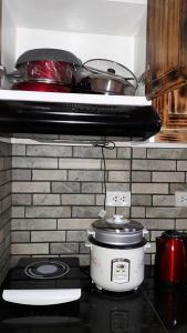 a stove with pots and pans on top of it at The Treehouse A @ Trees Residences in Manila