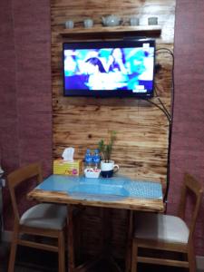 a table with two chairs and a television on a wall at The Treehouse A @ Trees Residences in Manila