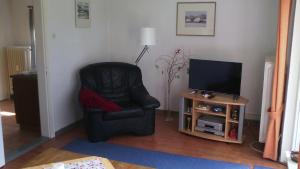 ブットヤーディンゲンにあるZur Kajüteのリビングルーム(黒い椅子、テレビ付)