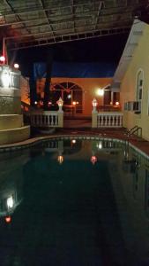 a swimming pool at night with lights in the water at The Wayside Inn in Matheran