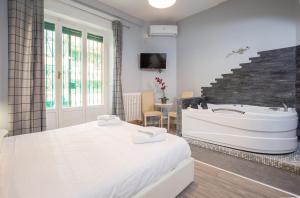 - une chambre avec un lit blanc et une baignoire dans l'établissement Royal House Vaticano, à Rome