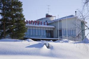 a hotel building with snow in front of it at Hotel Himos in Jämsä