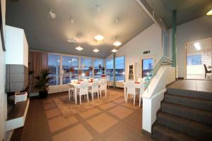 uma sala de jantar com mesa e cadeiras e o oceano em Hotel Himos em Jämsä