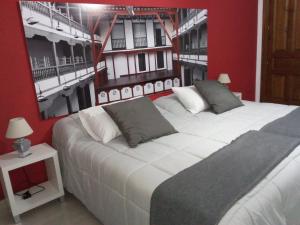 1 dormitorio con 2 camas y una foto en la pared en Casa Hormazas, en Almagro