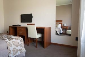 1 dormitorio con escritorio, TV y cama en Colón Center in 